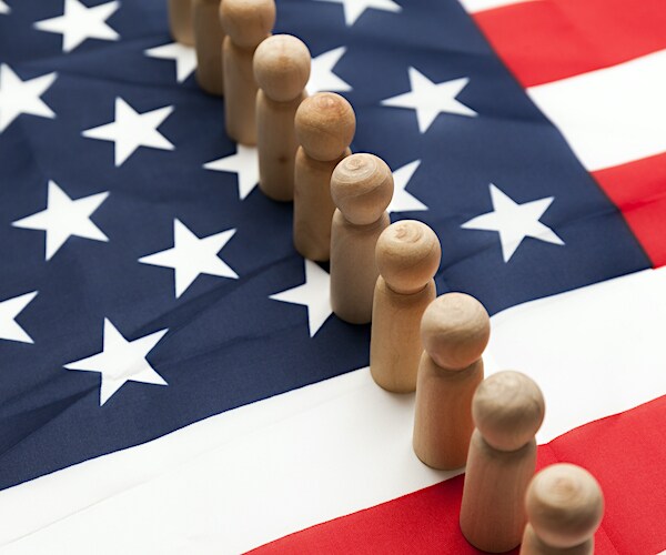 wooden pawns stand on an american flag in a graphic showing hire american