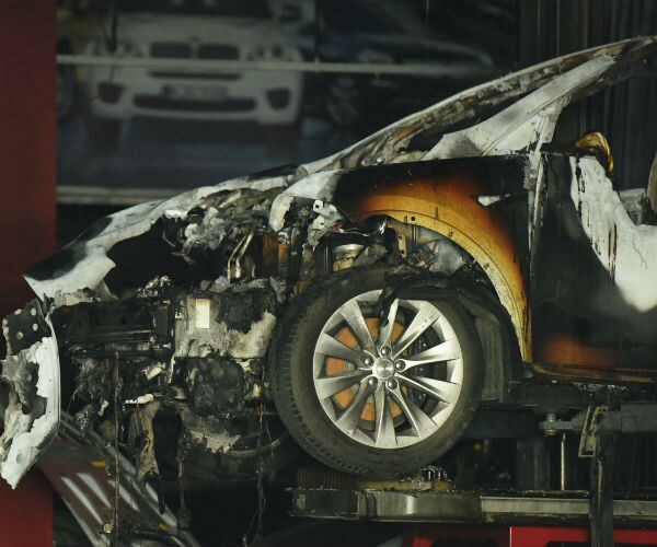 a burned tesla is shown aft the car's battery ignited 