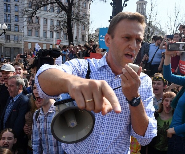 alexei navalny speaks into bullhorn in crowded square