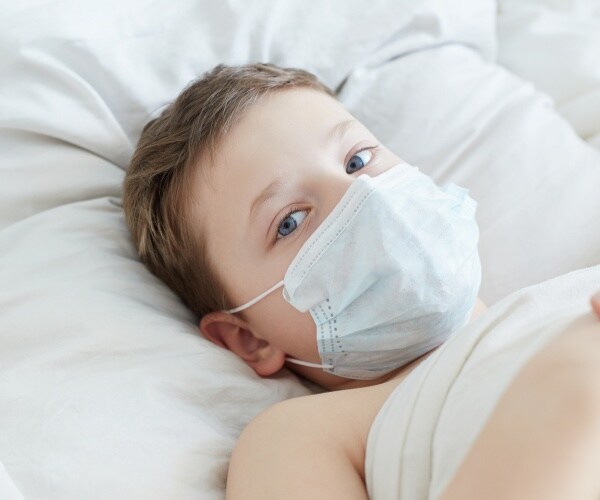 boy in hospital bed with mask