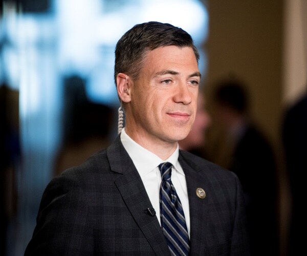 banks in a plaid dark gray suit with a striped tie