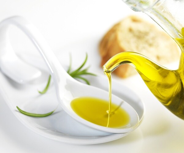olive oil being poured into spoon