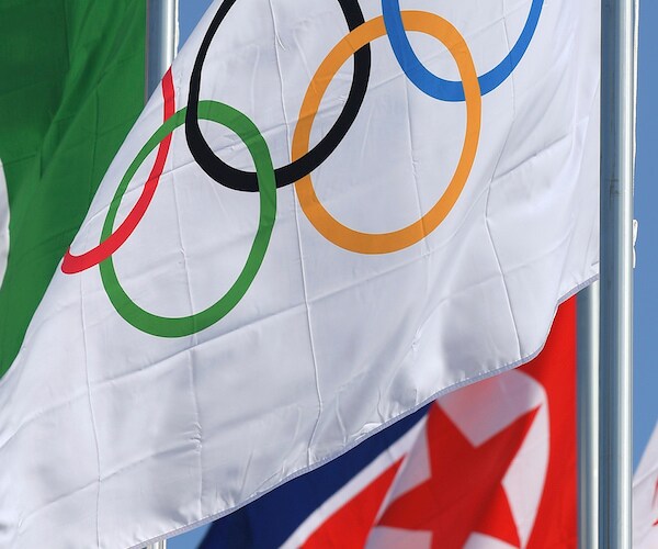 the olympic rings are shown on a flag waving in the breeze