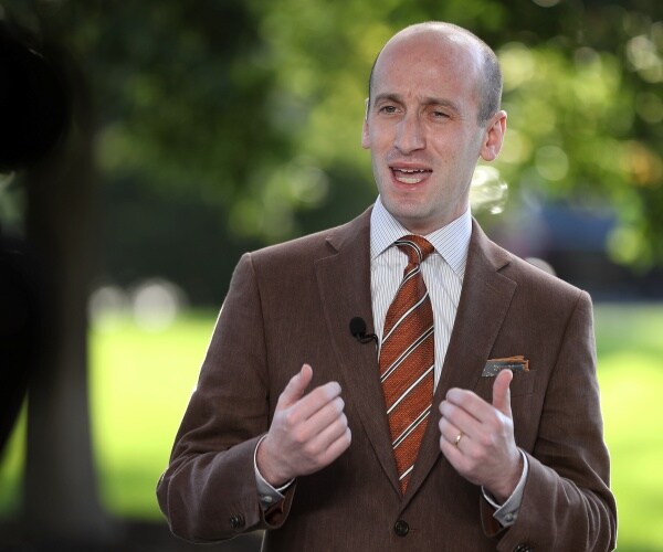 miller in a brown suit and orangey striped tie