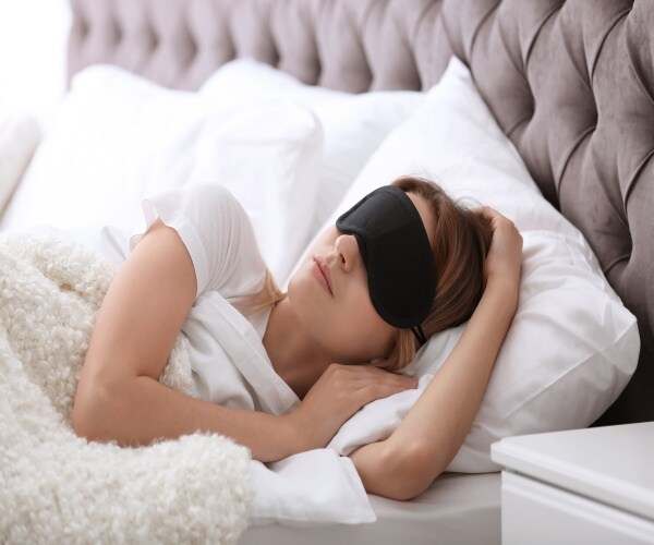 woman sleeping in bed with eye mask