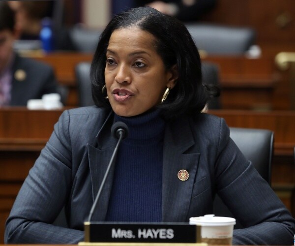 jahana hayes in a blue sweater top and blazer speaking at a hearing