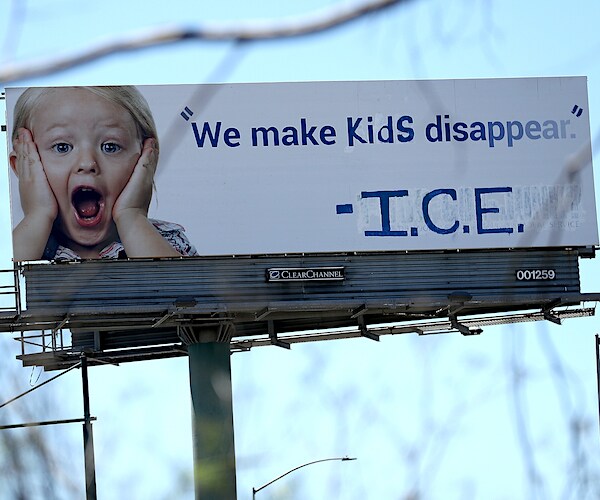 vandalized billboard shows a message in protest with the Immigration and Customs Enforcement