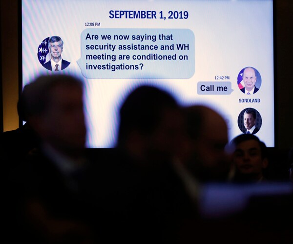 A text message between two top U.S. diplomats is displayed during a congressional hearing on impeachment