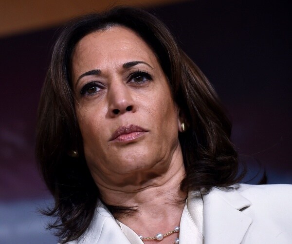 harris in a white suit and pearl necklace