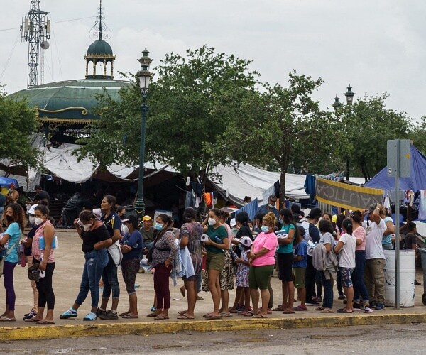 migrants wait in line