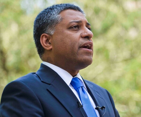 rahul gupta speaks into microphone