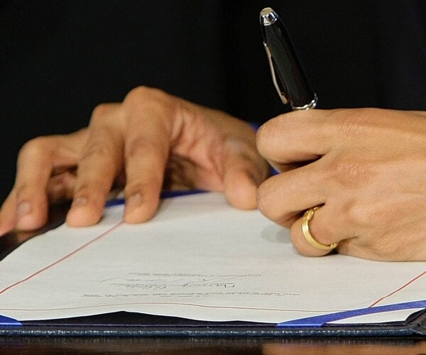 barack obama signs affordable care act into law