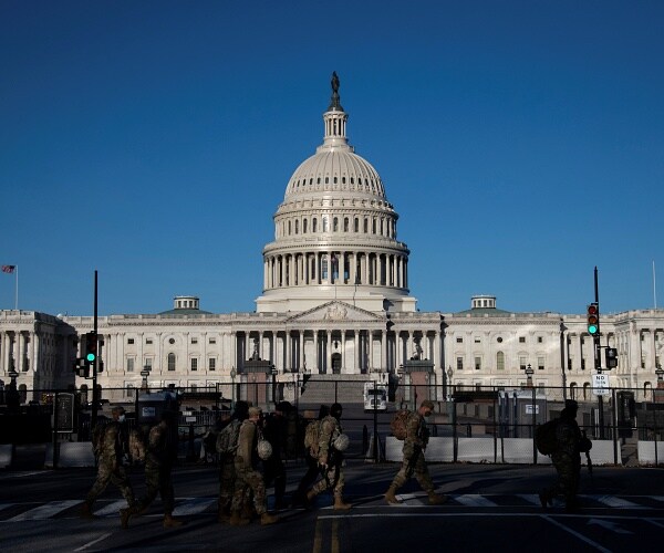 national guard members walk by capitol building