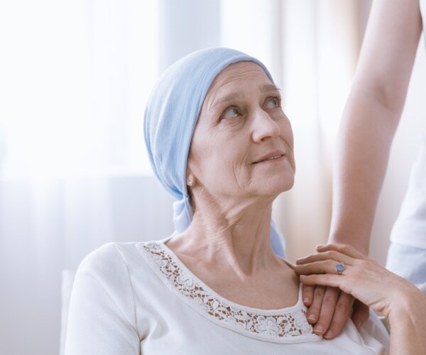 cancer patient wearing a white t shirt and blue head wrap