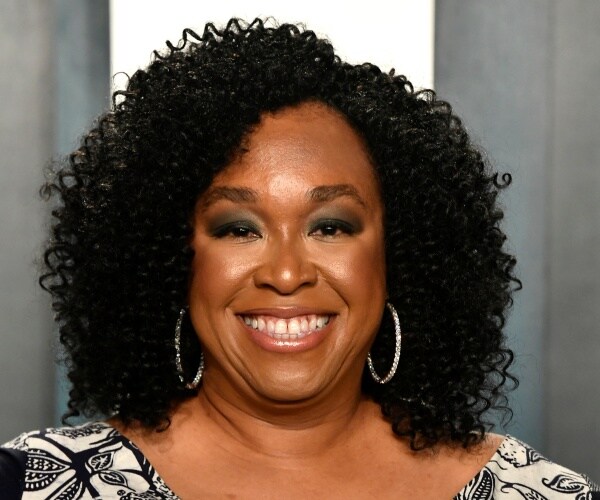 rhimes in a black and white patterned dress