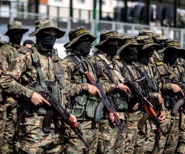 masked fighters hold guns