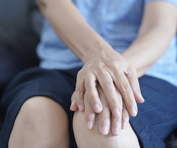 a woman holding her knee in pain