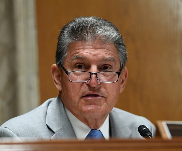 joe manchin sits behind table at hearing