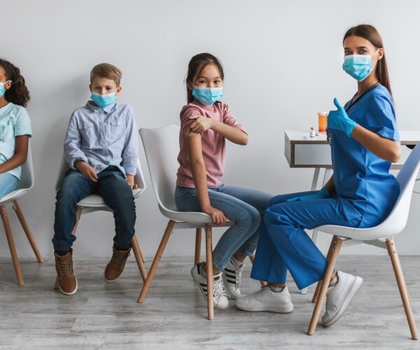 kids getting COVID vaccine, healthcare worker with thumbs up