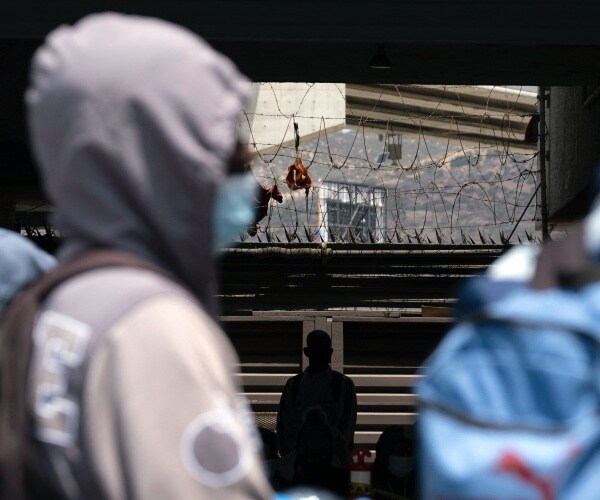 Asylum seekers stand outside a community center