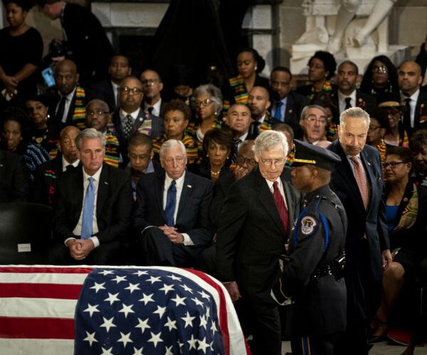 mitch mcconnell and chuck schumer look over at the flag draped coffin of the late rep. elijah cummings