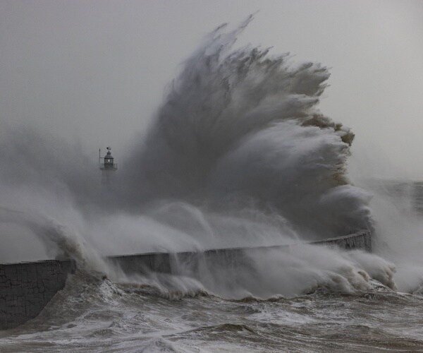 Storm waves batter the Newhaven breakwater and Lighthouse in Newhaven, England