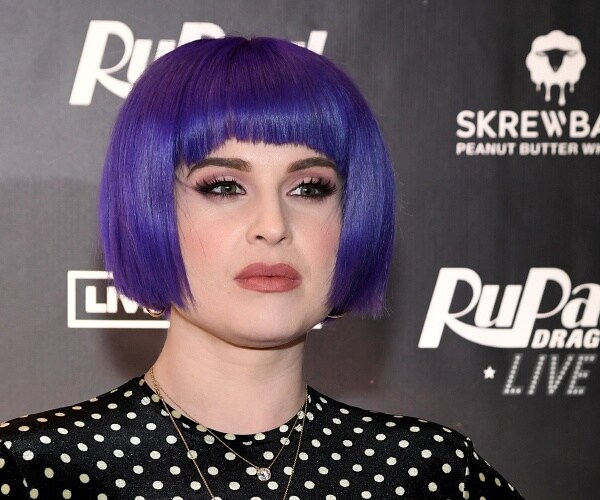 kelly osbourne stands on red carpet
