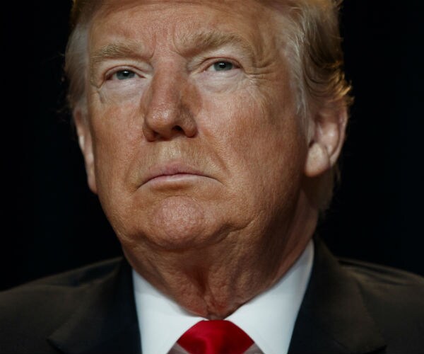 donald trump is shown in suit, white dress shirt and red tie