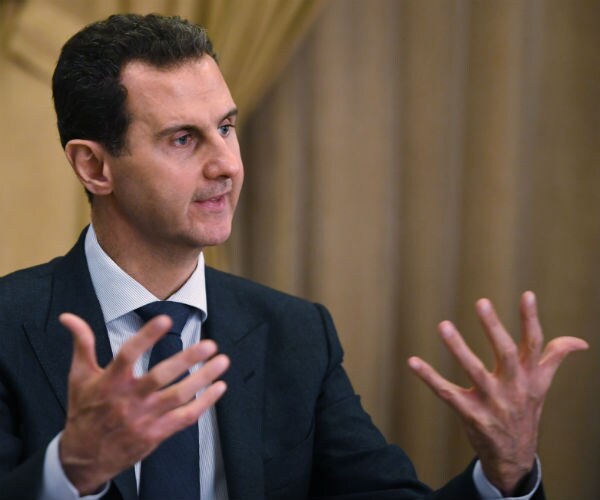 Syrian President Bashar al-Assad gestures with his hands as he speaks