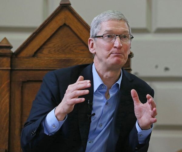 tim cook gestures while speaking during a meeting