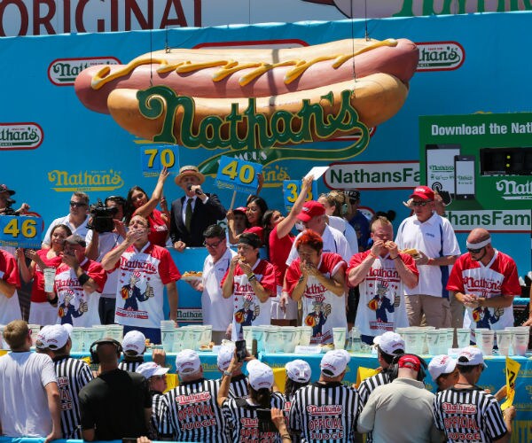 Participants compete during the men's hot dog eating contest on July 4, 2019 in New York City.