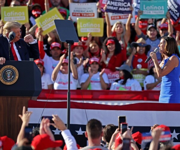 martha mcsally holds a mic at a rally looking at president trump