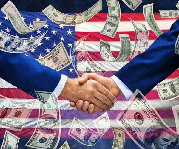 pair of businessmen shaking hands with an american flag and money falling down around them 


