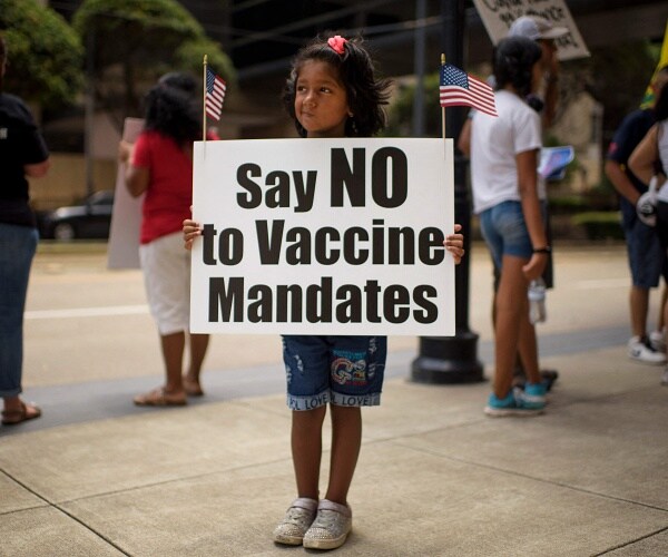 little girls holds a sign that says say no to vaccine mandates