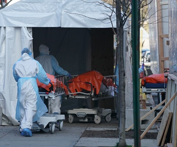bodies are wheeled into a makeshift morgue
