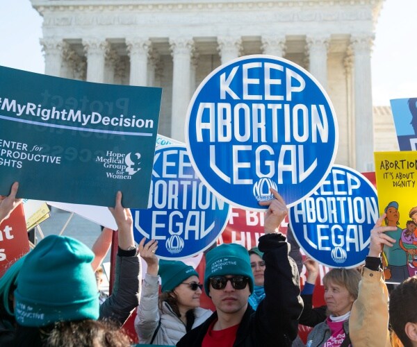 pro choice activists hold up signs outside the supreme court