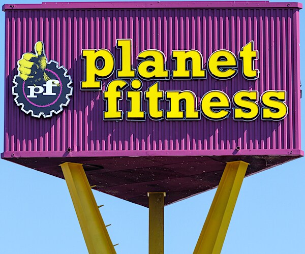 a woman leads a yoga workout with a downward dog pose