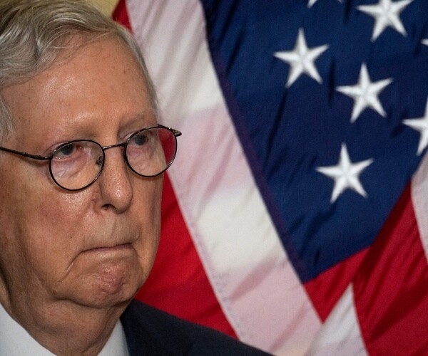 mitch mcconnell stands in front of american flag