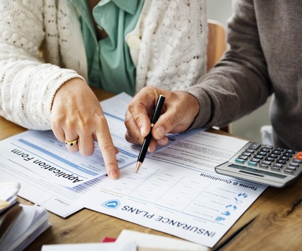 man and woman looking at insurance forms 