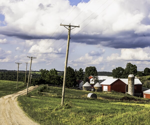 a farm with a red barn on a dirt road in rural ohio