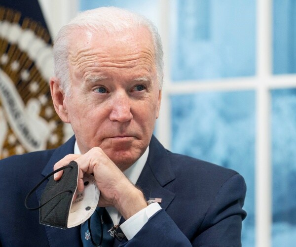 President Joe Biden listens during a virtual meeting.