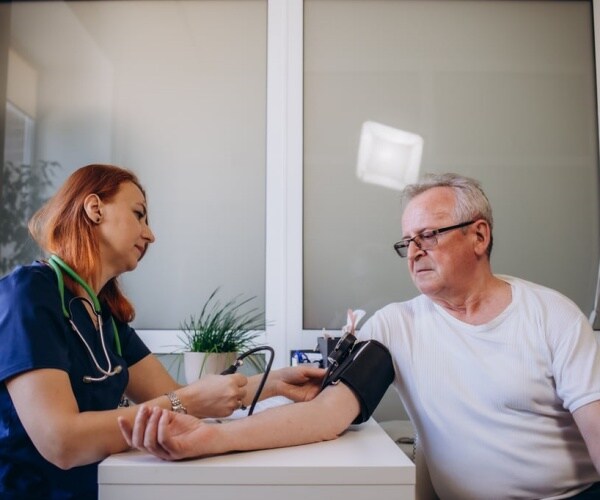 Healthcare worker taking man's blood pressure
