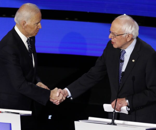 former vice president joe biden and sen. bernie sanders shake hands before a debate