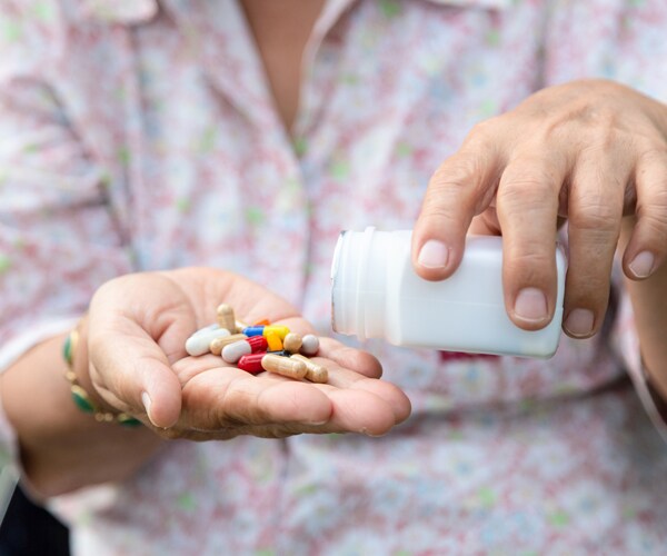 a senior citizen holding medicine