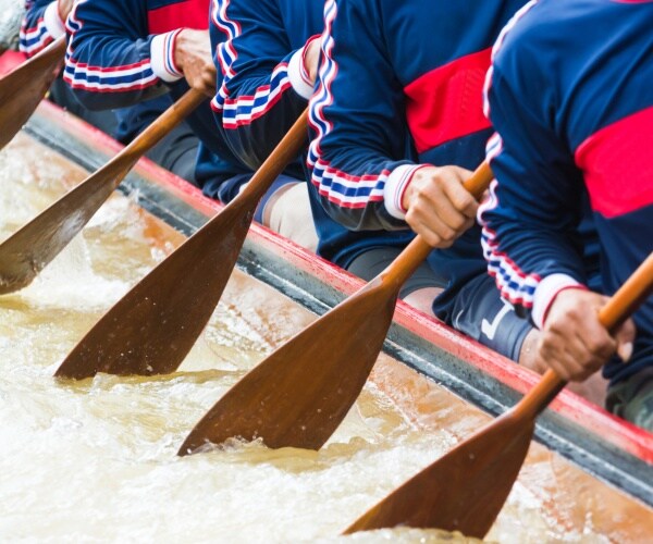 crew team members in red and blue uniforms row