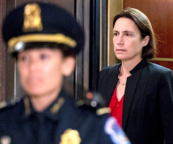 fiona hill walks out of a briefing remove behind a police escort