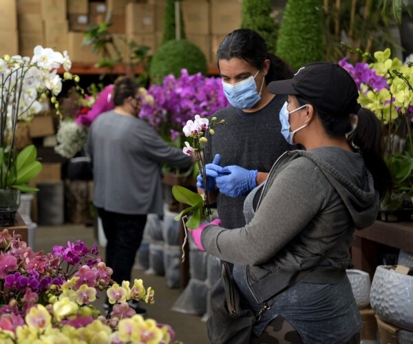 people wear masks and pick out flowers at the la flower district