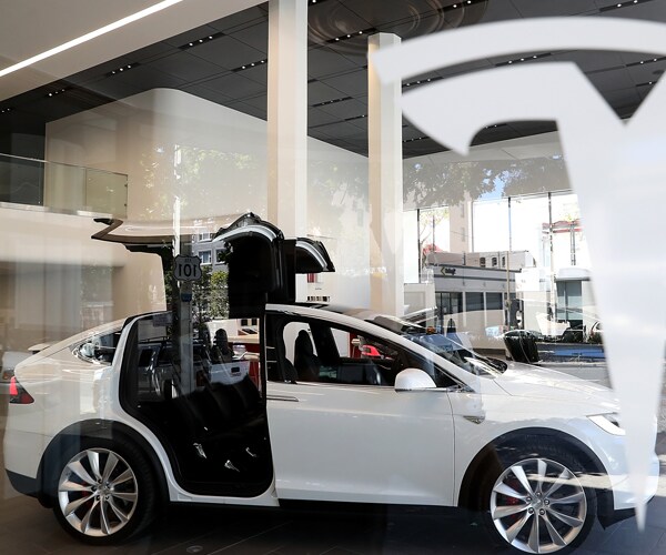 a tesla model x with its doors open