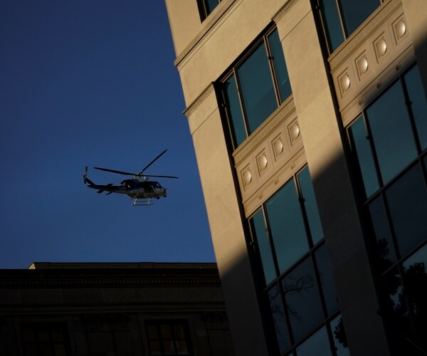 helicopter is seen in the sky next to a building