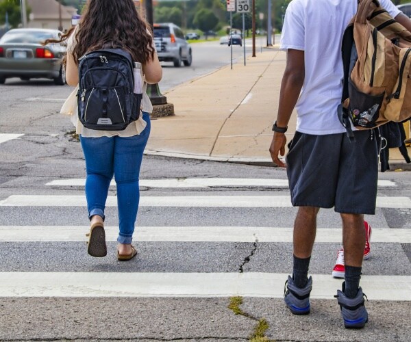 students walking to school with cars going by